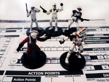 Miniature gaming figures stand atop RPG data sheets.