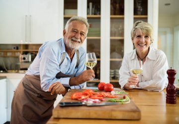 A mature man and woman in a kitchen.